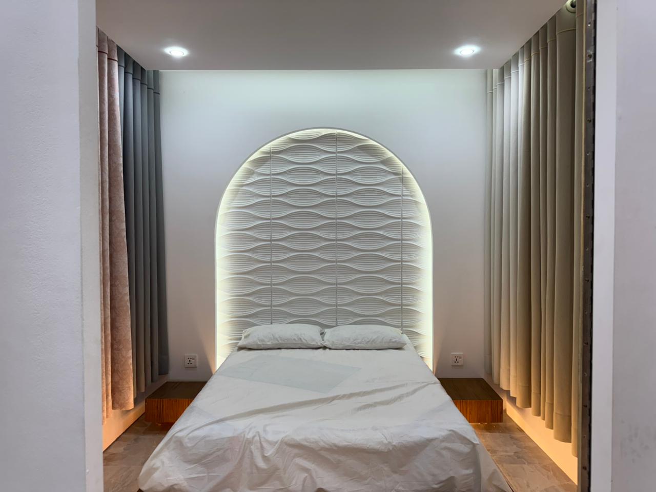 Bedroom curtain design with elegant drapes and upholstered headboard by Curtivelle
