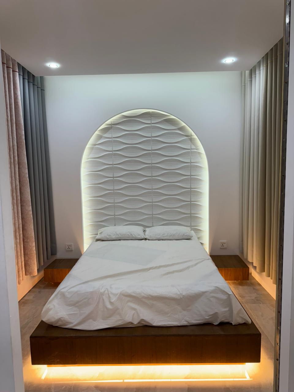 Bedroom curtain design with elegant drapes and upholstered headboard by Curtivelle