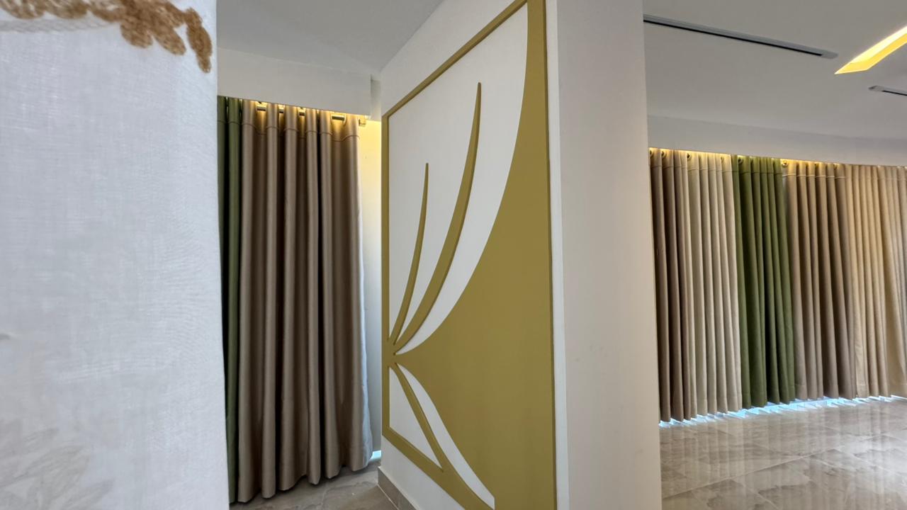 Curtivelle branded showroom wall with premium curtain displays