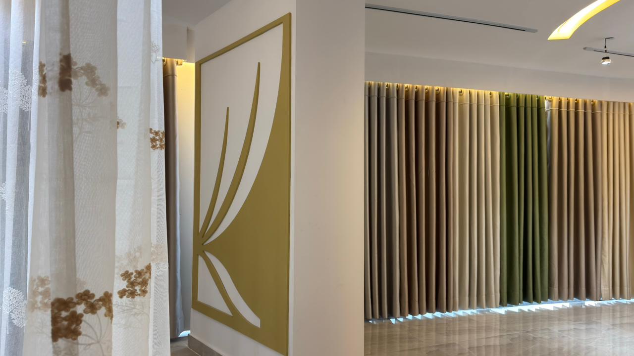 Curtivelle branded showroom wall with premium curtain displays