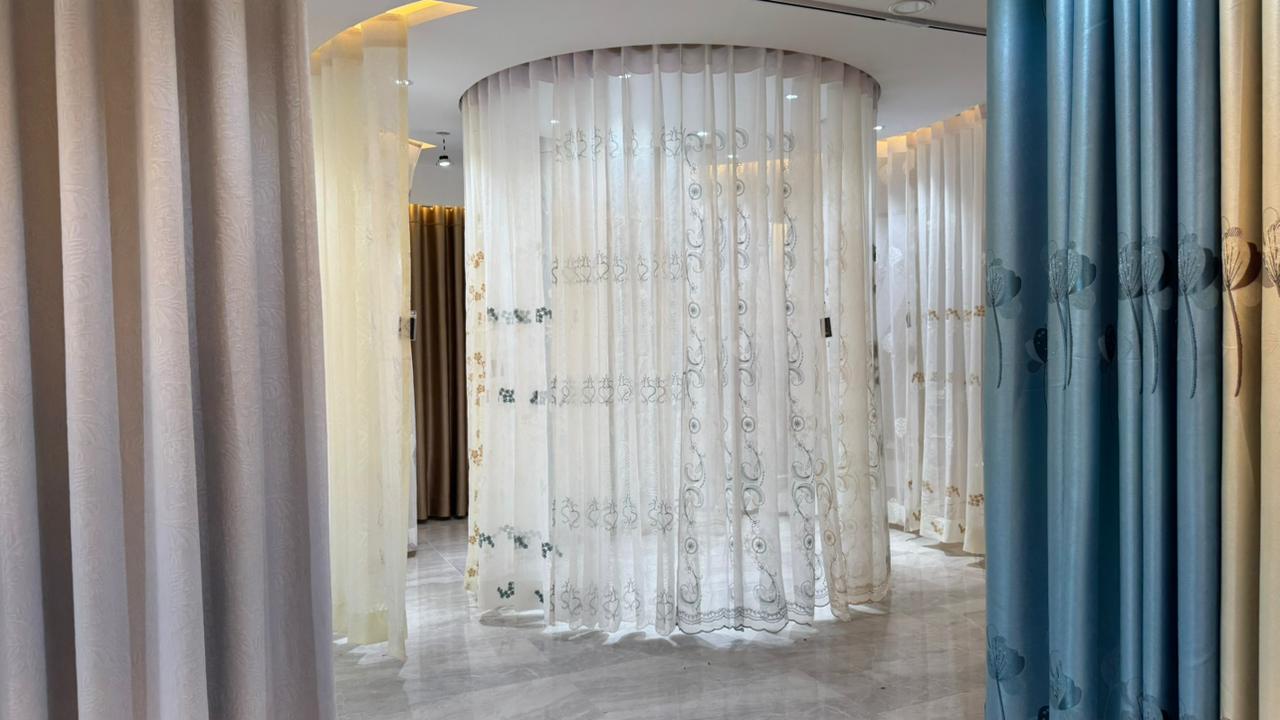 Circular sheer curtain display with blue drapes in luxury showroom