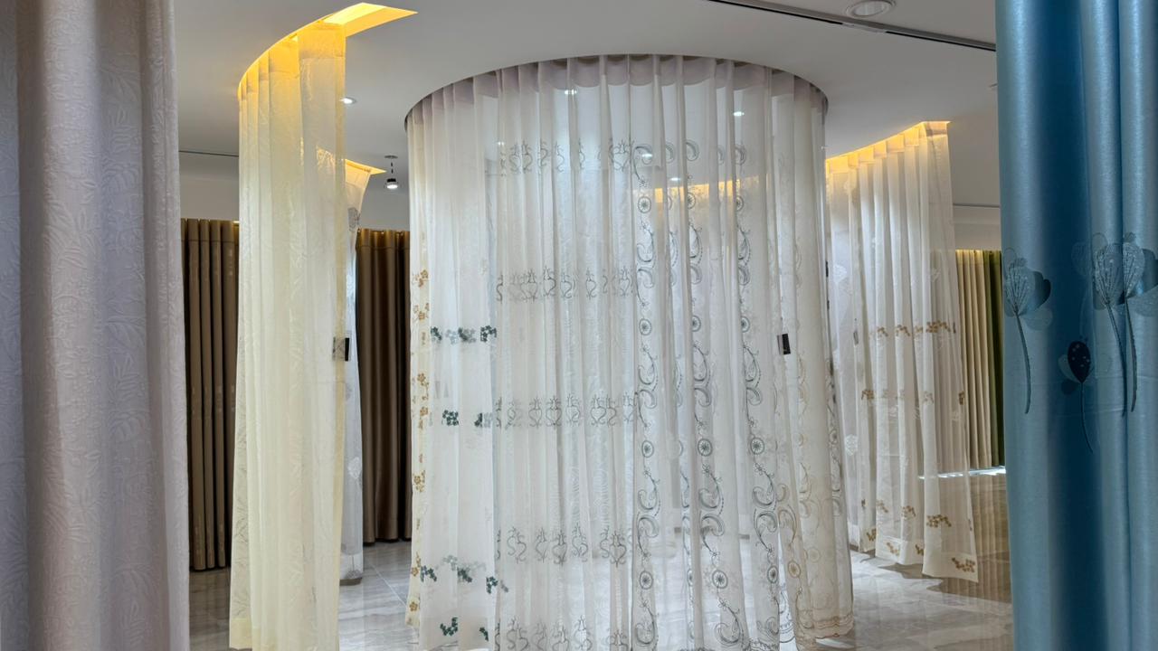 Circular sheer curtain display with blue drapes in luxury showroom