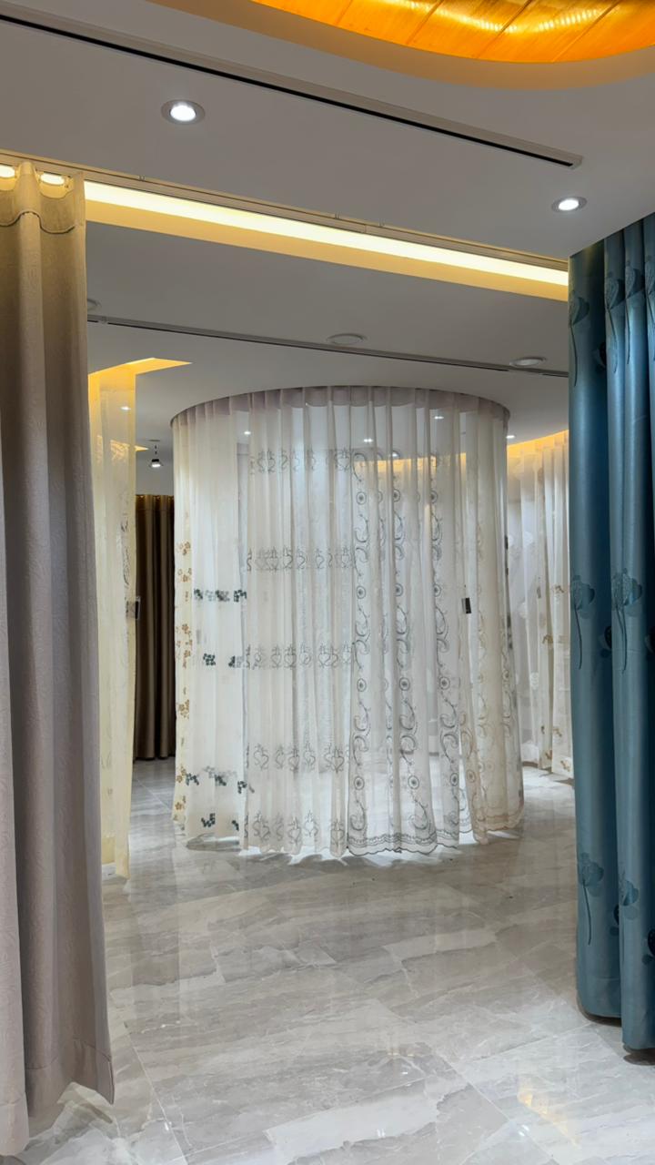 Circular sheer curtain display with blue drapes in luxury showroom