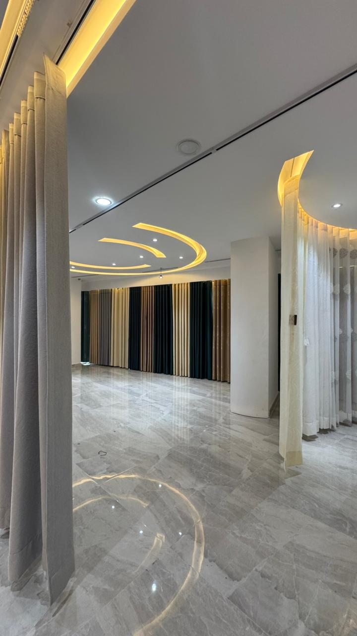 Curtivelle showroom window curtain installation with grey and blue drapes