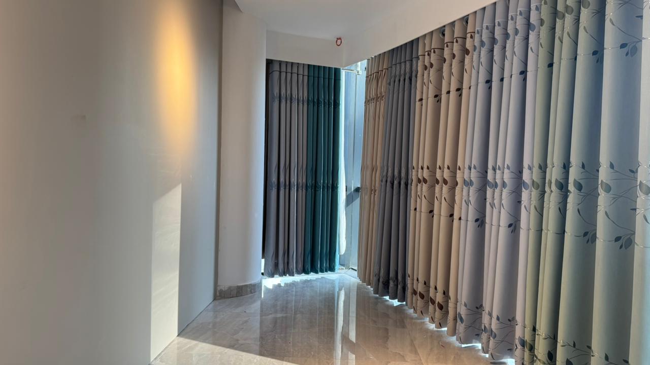 Curtivelle showroom window curtain installation with grey and blue drapes
