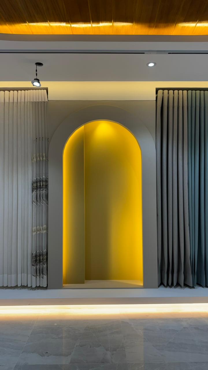 Curtivelle showroom window curtain installation with grey and blue drapes