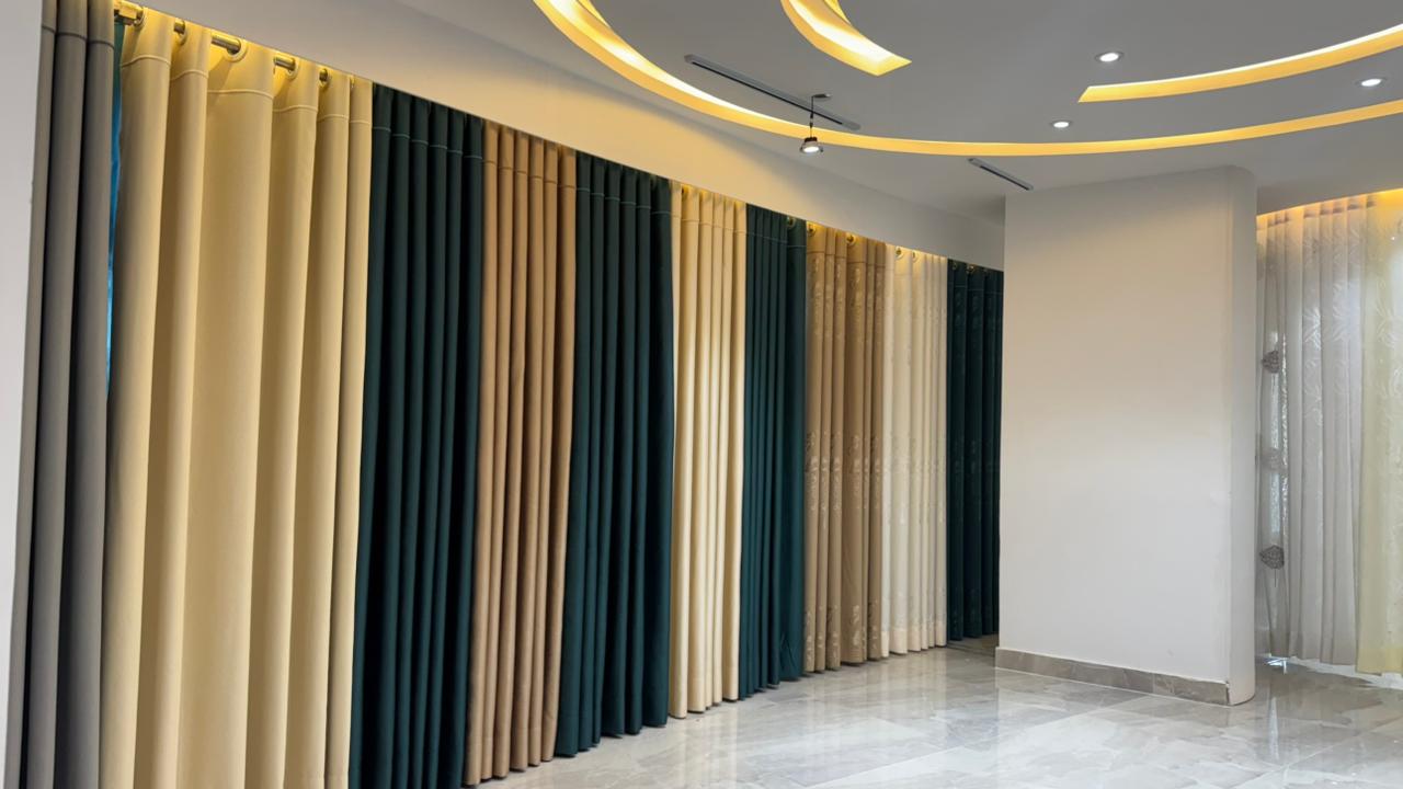 Curtivelle showroom window curtain installation with grey and blue drapes