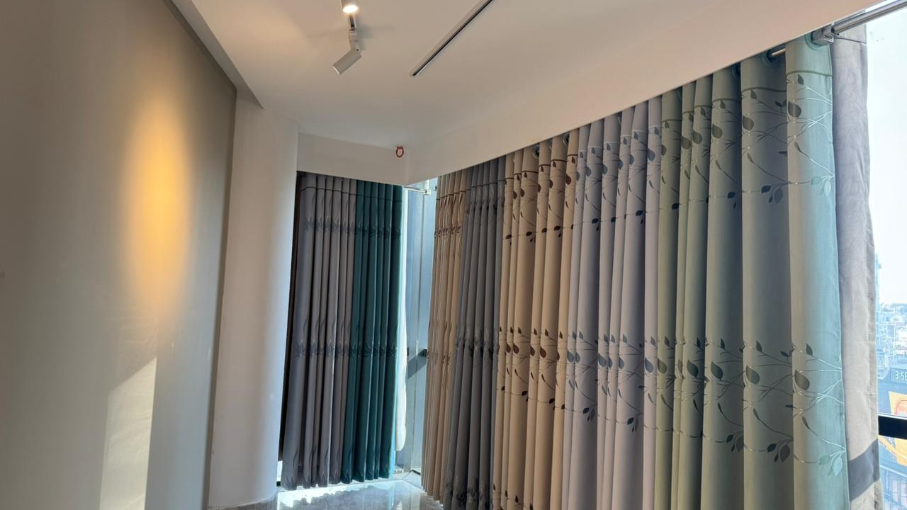 Curtivelle showroom window curtain installation with grey and blue drapes