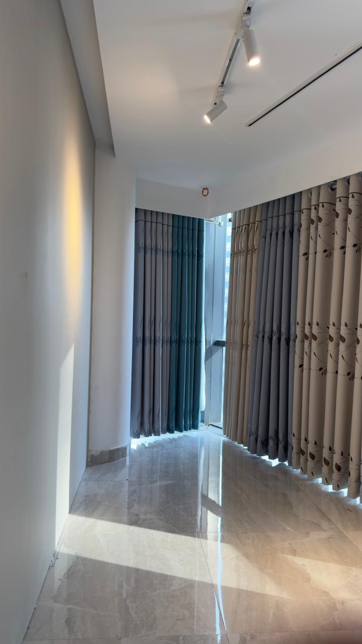Curtivelle showroom window curtain installation with grey and blue drapes