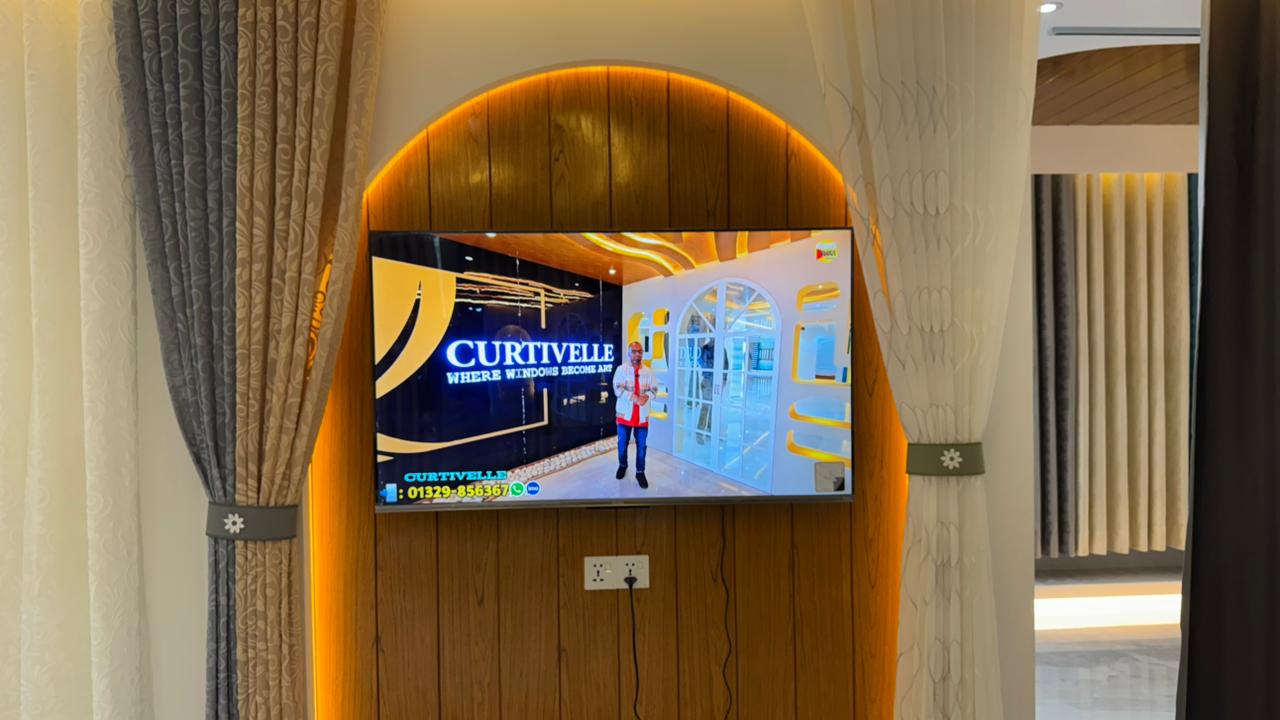 Curtivelle showroom media wall with sheer and blackout curtain displays