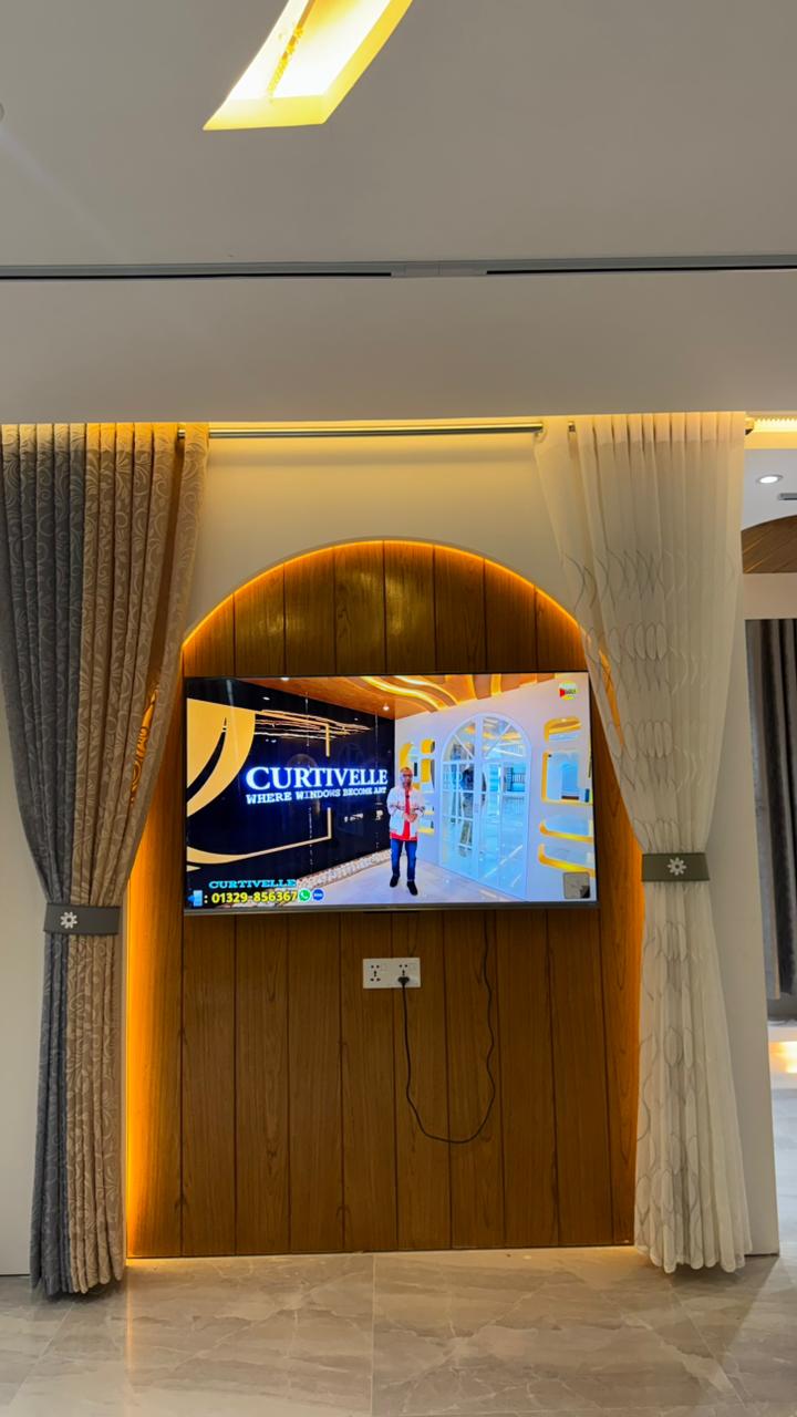 Curtivelle showroom media wall with sheer and blackout curtain displays