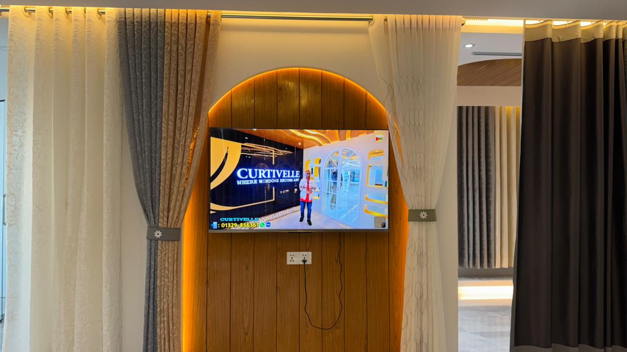Curtivelle showroom media wall with sheer and blackout curtain displays