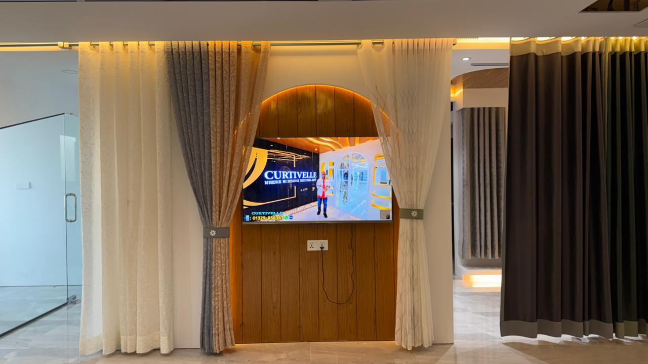 Curtivelle showroom media wall with sheer and blackout curtain displays