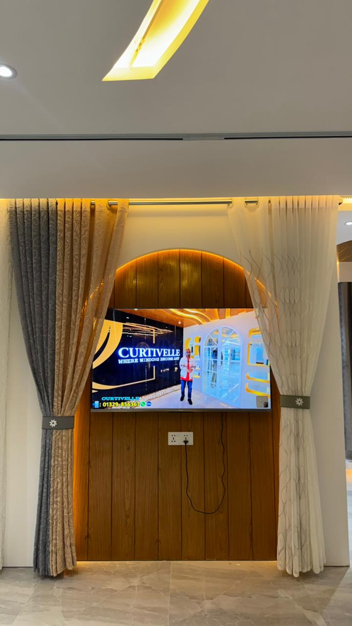 Curtivelle showroom media wall with sheer and blackout curtain displays